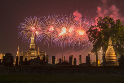 Firework display over city lit up at night