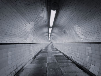 Rear view of man walking in tunnel