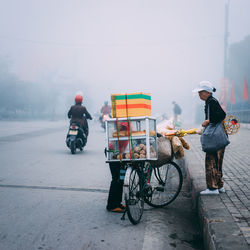 Man riding bicycle on road in city