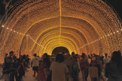 Group of people at illuminated historical building at night