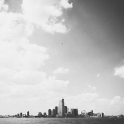 Skyscrapers in city against cloudy sky