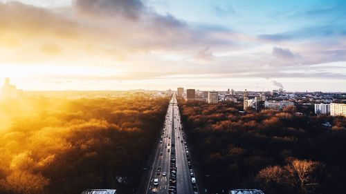 High angle view of street amidst buildings against sky during sunset