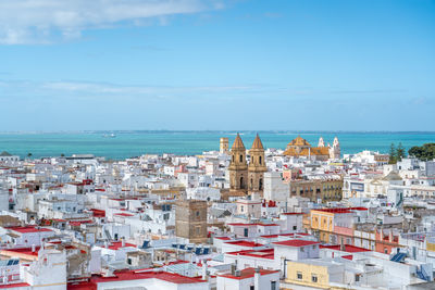 High angle view of townscape by sea against sky