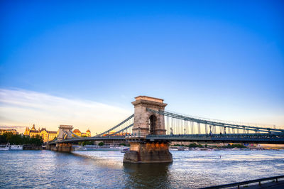 View of bridge over river against blue sky