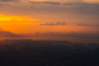 Scenic view of city against orange sky