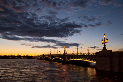 Bridge over river against sky during sunset