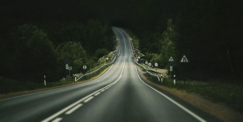 Road amidst trees at night