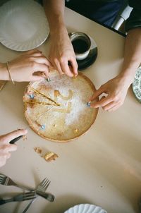 High angle view of hand holding cookies on table