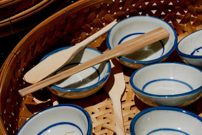 High angle view of bowls with spatulas in wicker container