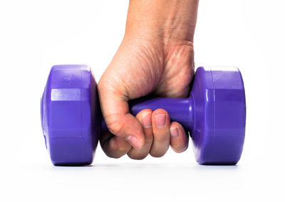 Close-up of hand holding blue over white background