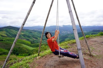 Full length of young man on mountain against sky