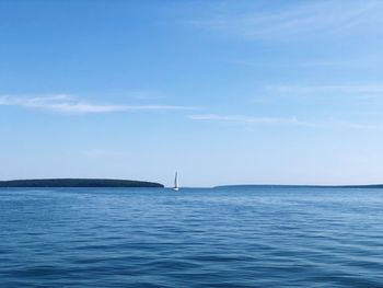 Sailboats in sea against blue sky