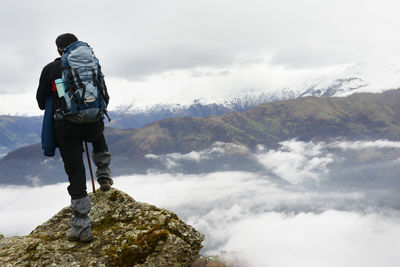 Man standing on rock against mountains