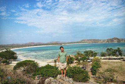 Portrait of man standing with sea in background against cloudy sky