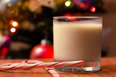 Close-up of drink by candy canes in glass on table
