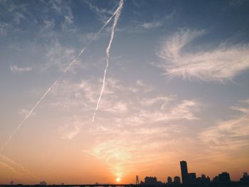 Scenic view of vapor trails in sky during sunset