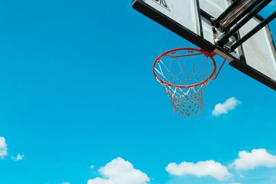 Low angle view of basketball hoop against blue sky