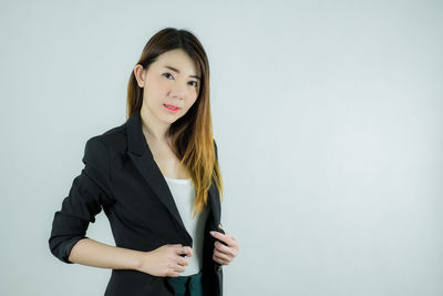 Portrait of a smiling young woman against white background