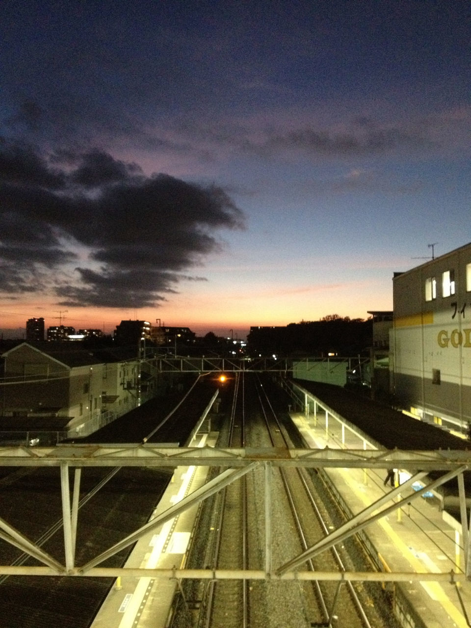 architecture, built structure, building exterior, transportation, city, railroad track, sky, sunset, public transportation, rail transportation, high angle view, city life, railroad station, cityscape, illuminated, cloud - sky, dusk, mode of transport, railroad station platform, travel