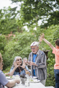 Multi-generational family enjoying lunch in back yard