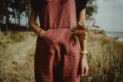 Midsection of woman standing on field