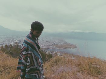 Man standing by sea against sky