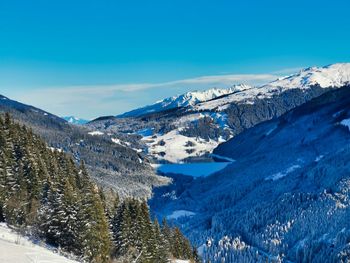 Scenic view of snowcapped mountains against blue sky