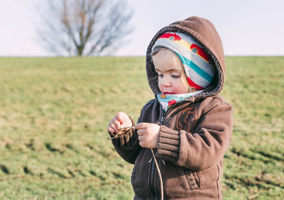 Cute boy looking away on field