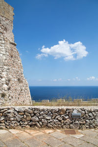 Stack of rocks by sea against sky