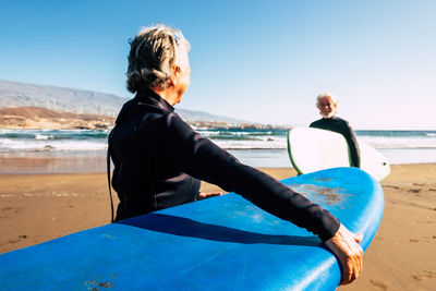 Rear view of woman on beach against clear sky