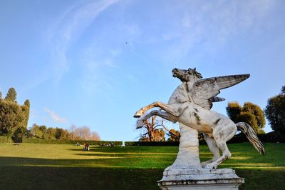 Statue in park against blue sky