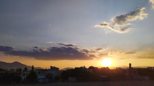 Silhouette buildings against sky during sunset