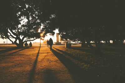 Silhouette people walking on footpath at night