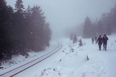 People skiing on snow covered landscape