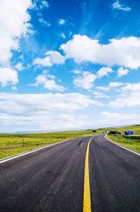 Empty road leading towards dramatic sky