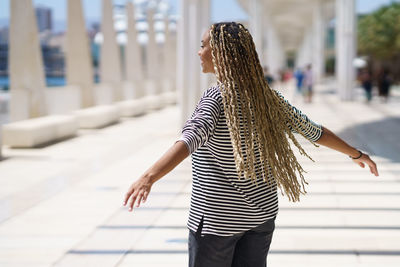 Rear view of woman standing on footpath