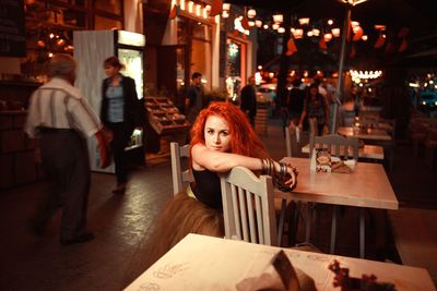 Portrait of young woman sitting in restaurant