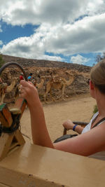Portrait of man holding hands on sand against sky