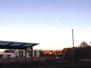 Houses by street against sky during sunset