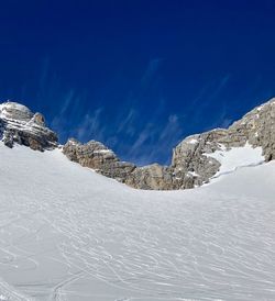 Scenic view of snowcapped mountains against blue sky