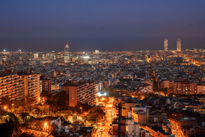 High angle view of illuminated cityscape against sky at night