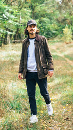 Portrait of young man standing against trees