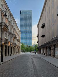 Street amidst buildings against sky in city