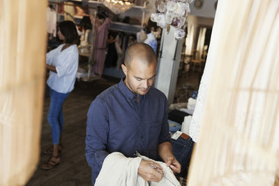 Owner checking textile while female colleague working in background