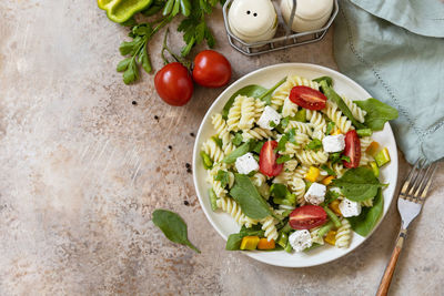 Salad with gluten free pasta, spinach, tomatoes, beans and feta cheese.