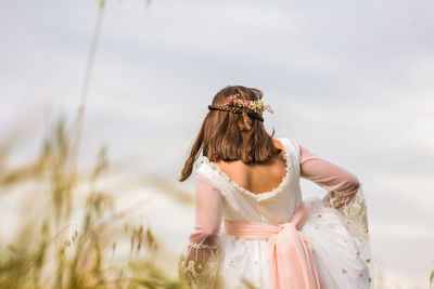 Rear view of girl standing against sky