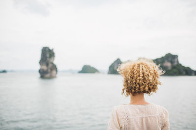Rear view of woman looking at sea against sky