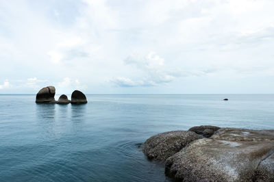 Scenic view of rocks in sea against sky