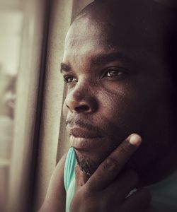 Close-up portrait of man looking through window