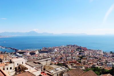 High angle view of townscape by sea against sky